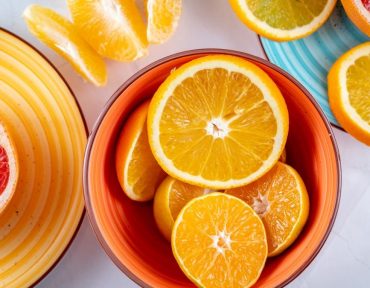 Citrus slices creatively arranged in ceramic bowls, showcasing a vivid and fresh presentation of grapefruits and oranges.